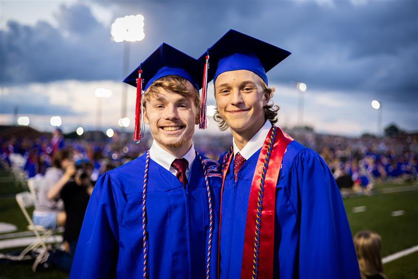 Students in blue robes graduate